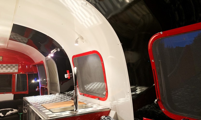 Cuisine d'une caravane aménagée rouge noir blanche