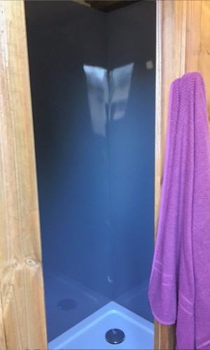 Douche de camping protégée par des plaques en PVC grises
