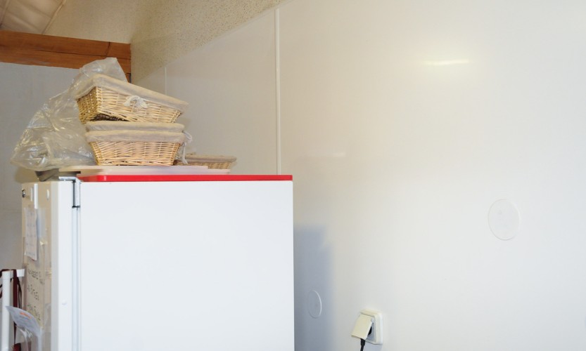 Pose de plaques en PVC derrière un frigo