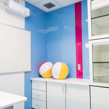Salle de consultation médicale avec panneau mural décoratif brillant rose "shocking pink" Altro Whiterock Chameleon et bleu "Slip Stream"
