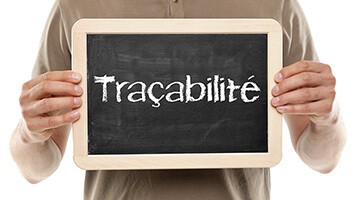 Personne tenant une ardoise sur laquelle est écrit : traçabilité alimentaire
