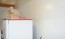 Pose de plaques en PVC derrière un frigo